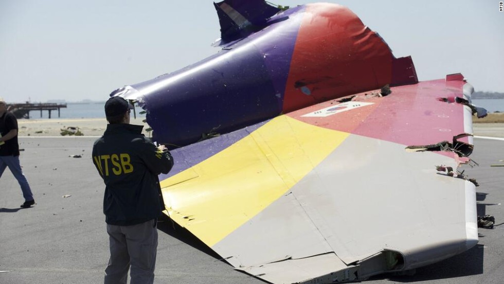 An investigator inspects the broken-off tail of the plane in a handout photo released July 7. The crash killed two people, injured 182 and forced the temporary closure of one of the country&#39;s largest airports.