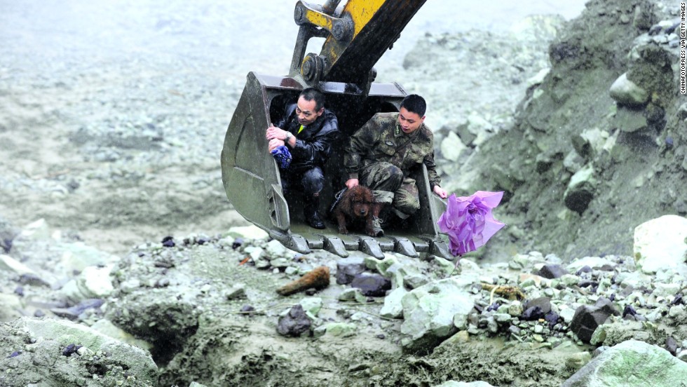 Rescuers evacuate residents with an excavator on Wednesday, July 10, after a landslide hit Wenchuan, China. Flooding that triggered the landslide reportedly has affected 1.5 million people.