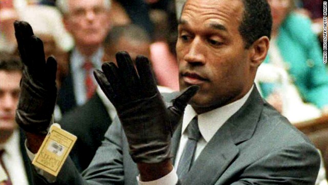 O.J. Simpson looks at a new pair of Aris extra-large gloves that prosecutors had him put on 21 June 1995 during his double-murder trial in Los Angeles. Simpson was acquitted of charges of murdering his ex-wife Nicole Simpson and her friend Ronald Goldman.  AFP PHOTO by Vince BUCCI (Photo credit should read Vince Bucci/AFP/Getty Images)