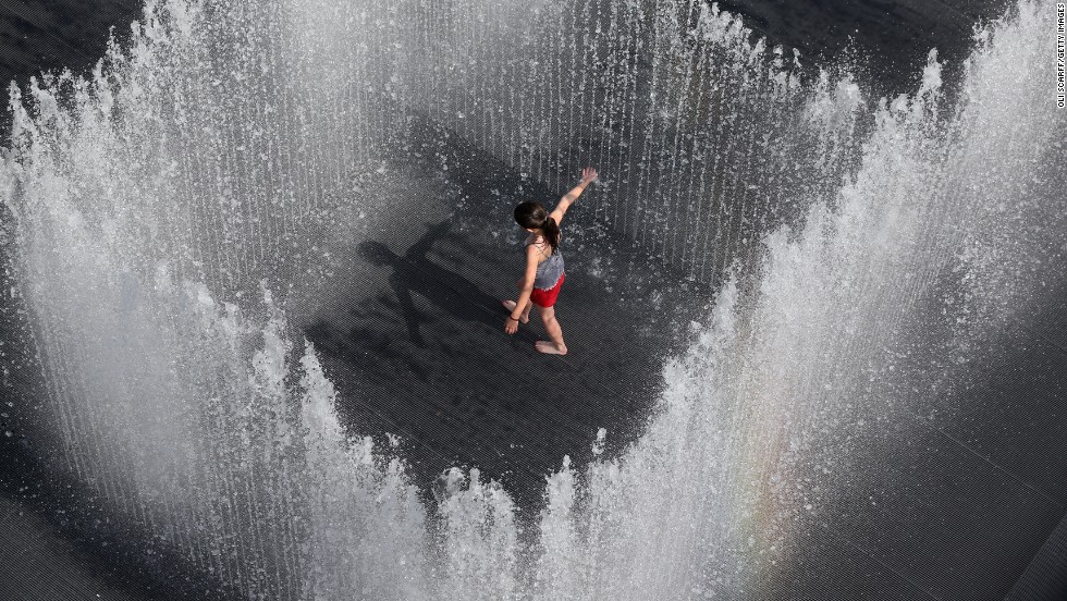A girl plays in the fountain called &quot;Appearing Rooms,&quot; by Danish artist Jeppe Hein, in central London on July 18. The United Kingdom is experiencing a second week of heatwave conditions.