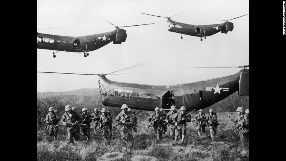 U. S. tropper dukker op fra helikoptere på et åbent felt omkring 1953.