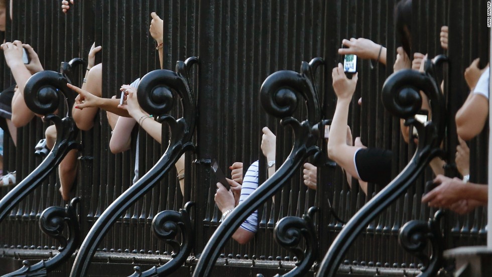 Revelers crowd against the railing of Buckingham Palace in London after an official notice proclaiming the birth was put on display on July 22.