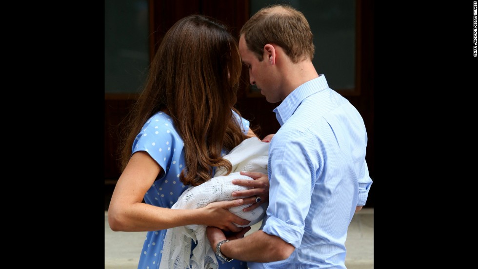 Catherine hands the baby off to William. 
