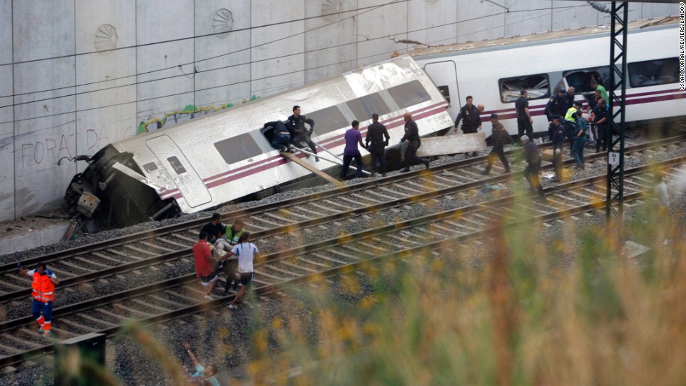Rescuers work to clear a derailed car. 