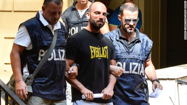 Police officers in central Rome lead away one of dozens arrested for organised crime in Ostia on July 26, 2013.