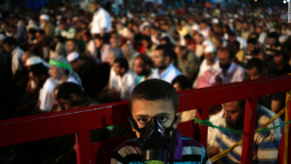 A boy wears a tear gas mask as supporters of Egypt&#39;s ousted President Mohammed Morsy pray at the camp set up by supporters in the Nasr City area of Cairo on July 28.  