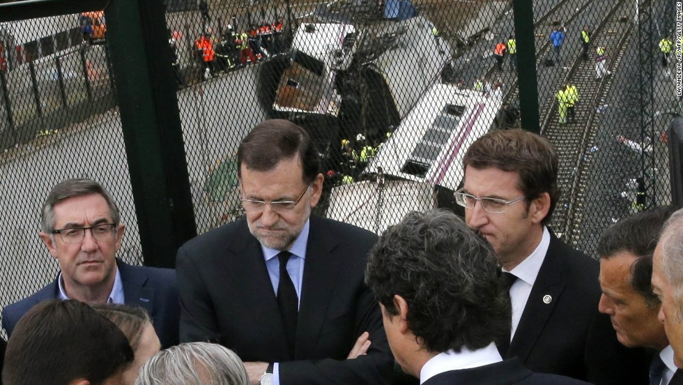 Spanish Prime Minister Mariano Rajoy, second from left, and Galicia&#39;s regional President Alberto Nunez Feijoo, right, visit the site of the derailment on Friday, July 26.
