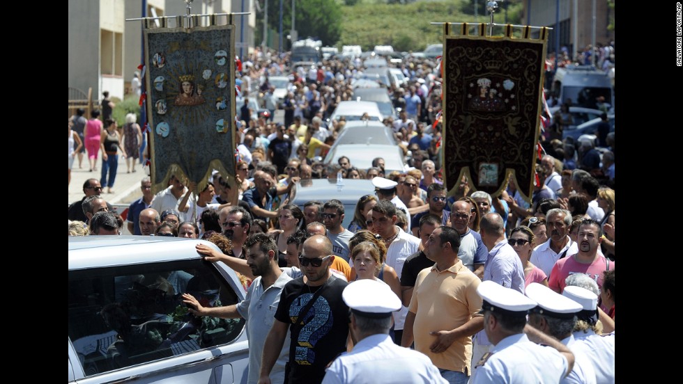 A crowd follows the hearses July 30. 