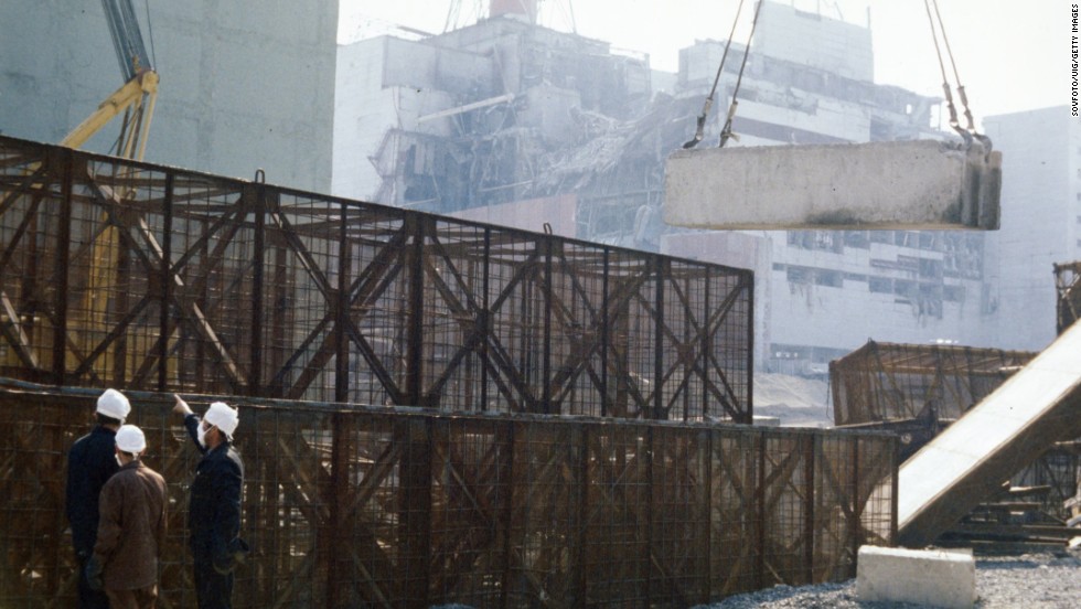 Construction crews build a containment wall around the damaged unit four reactor in August 1986. 