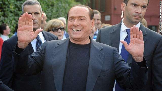 Italy&#39;s former Prime Minister Silvio Berlusconi hails supporters in front of his house in Milan in 2013.