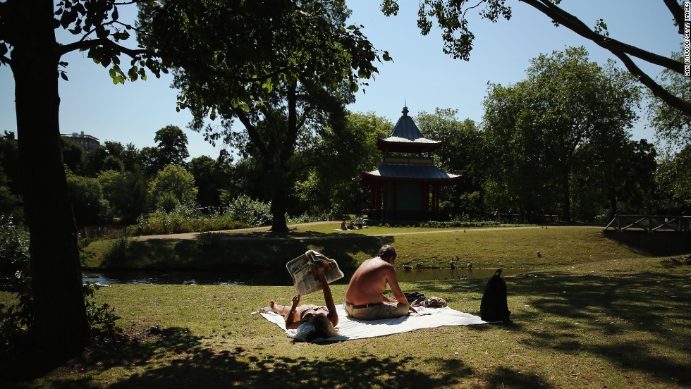 People relax in the sun in Victoria Park in London, on Thursday, August 1.