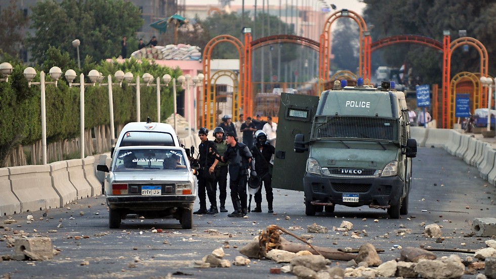 Egyptian riot police block the entrance to Sixth of October City in Giza on August 2 following clashes with Morsy supporters. 