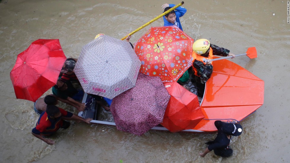 Members of the Philippine army paddle a boat with residents as they enforce an evacuation in Marikina City on August 20.