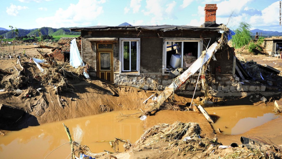 A damaged house sits in mud and floodwater in China&#39;s Liaoning province on August 19.