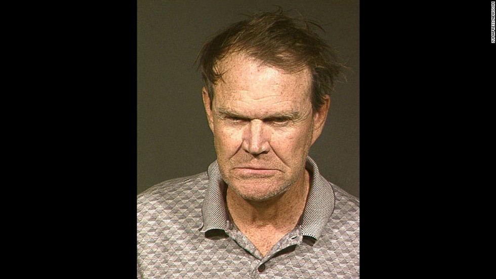 Country singer Glen Campbell was arrested in Phoenix on November 25, 2003, on drunken driving and hit-and-run charges. Campbell posed for his mugshot in 2004 after checking into a Phoenix lockup to serve his first of 10 nights in jail. He pleaded guilty to the charges.