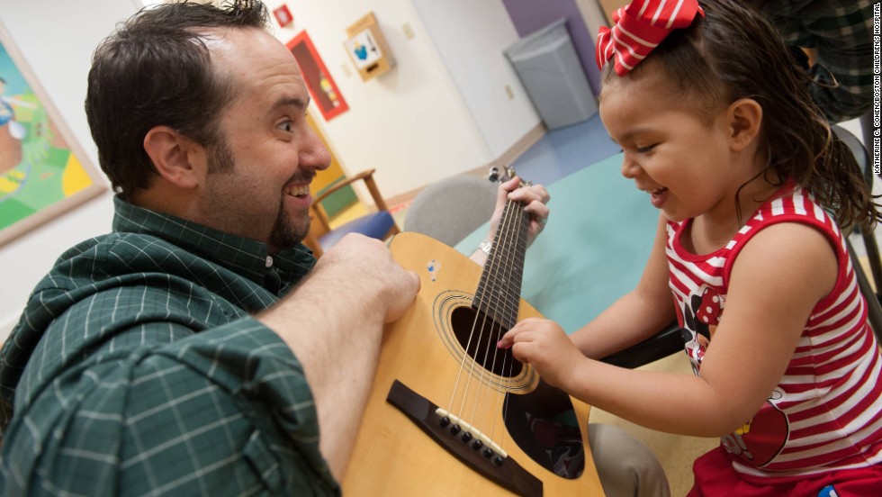 Brian Jantz, a music therapist at Boston Children&#39;s Hospital, plays with a patient, Yaneishka Trujillo. Jantz uses music to engage with children.