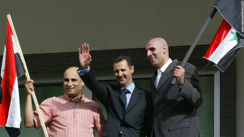 Two unidentified supporters of al-Assad join him on the balcony as he celebrates the referendum results in Damascus on May 29, 2007. Al-Assad won a second seven-year mandate after netting 97% of the vote in a referendum boycotted by the opposition.