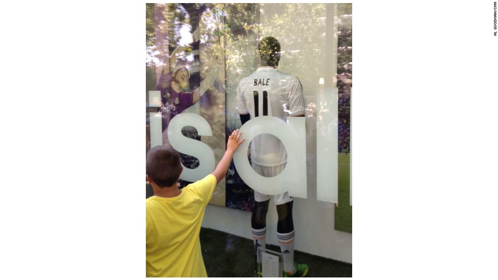 A young fan paws the window of the Real Madrid shop showcasing Gareth Bale&#39;s new shirt. 