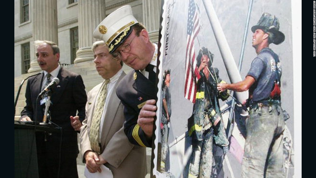 The stamp is displayed at a ceremony outside of the Brooklyn Borough Hall in New York on July 2, 2002. From left, Brooklyn Postmaster Joseph Lubrano, Borough President Marty Markowitz and Harold Meyers of the New York City Fire Department were in attendance.