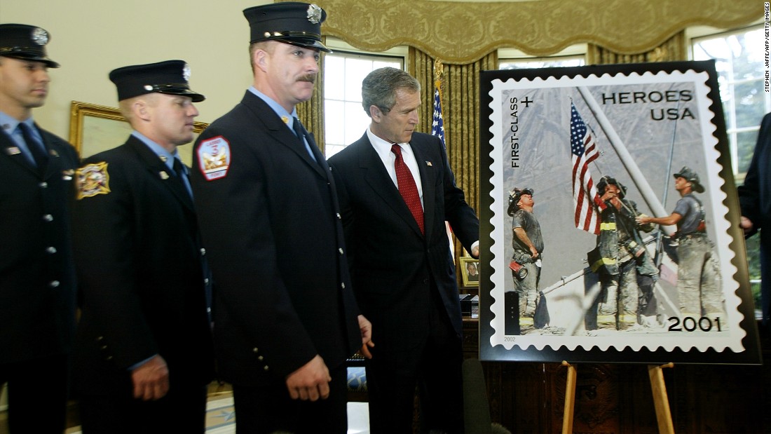 President George W. Bush unveils a &quot;Heroes of 2001&quot; stamp issued by the Postal Service on March 11, 2002, to raise funds to assist the families of emergency relief workers killed or permanently disabled as a result of the World Trade Center attacks. He is joined at the White House by the firefighters who are featured in the image, from left, Eisengrein, Johnson and McWilliams. 