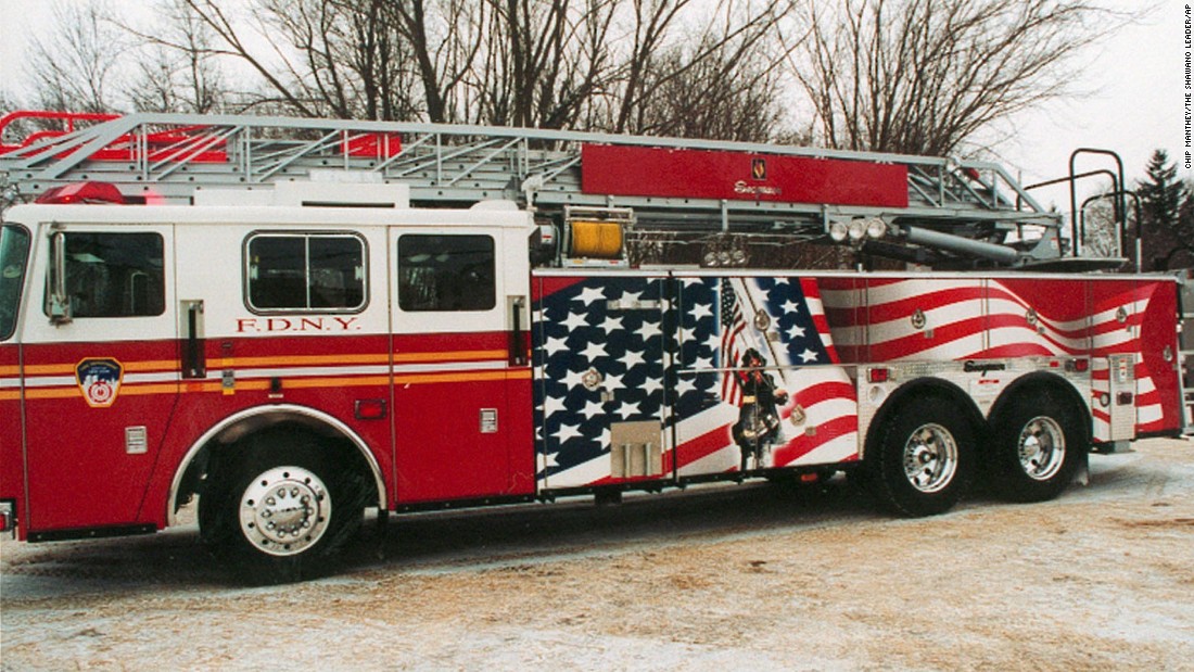 A firetruck that features a mural depicting a firefighter raising the flag is unveiled to the public in Clintonville, Wisconsin, on January 20, 2002. The truck was donated to the New York Fire Department.
