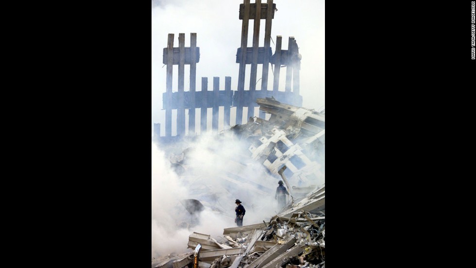 Firefighters stand in the smoldering wreckage of the World Trade Center on September 13, 2001.