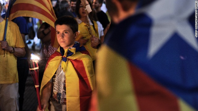 People wrapped in &#39;Estelada&#39; Catalan independence flags march during a rally for independence in Barcelona on September 10.