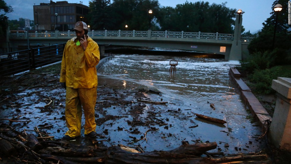 A city worker talks on his phone while surveying high water levels from Boulder Creek after flash flooding in downtown Boulder, Colorado, on September 12.