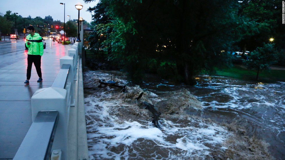 A man walks past the swelled Boulder Creek in Boulder on September 12.