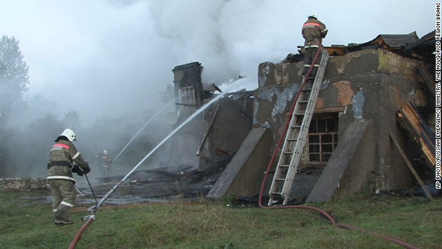 Fire fighters work at the site of a fire at a psychiatric hospital in Luka village, Novgorod region, Russia.