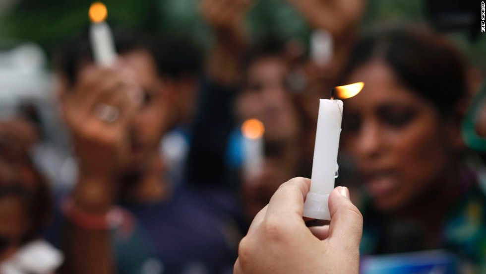 People hold candles outside the courthouse in New Delhi.