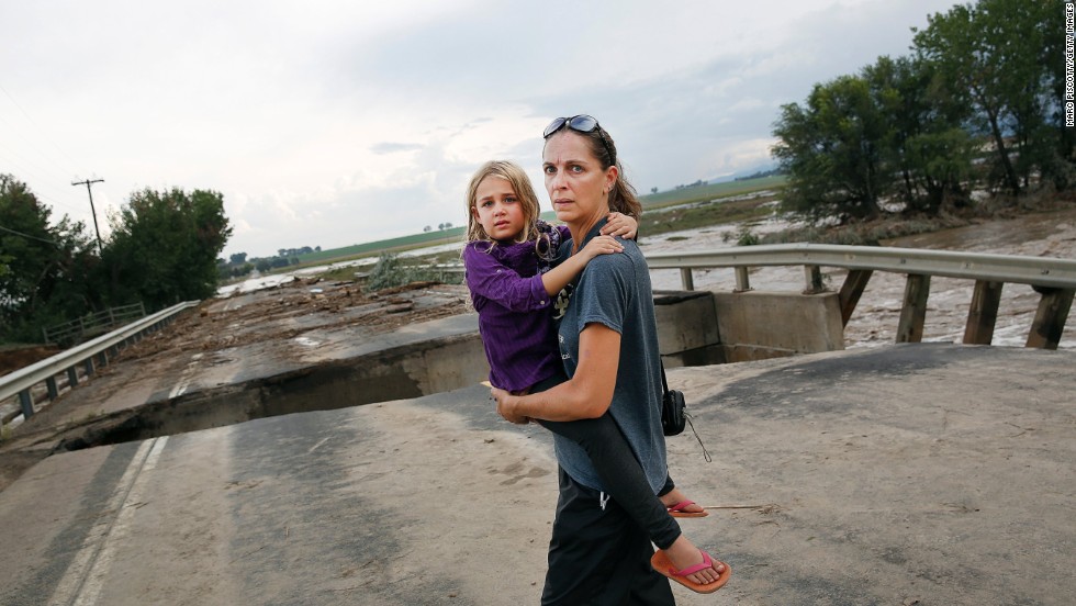 Samantha Kinzig of Longmont, Colorado, and her 5-year-old daughter, Isabel, take a closer look at the damaged bridge on Weld County Road 1 on September 13.