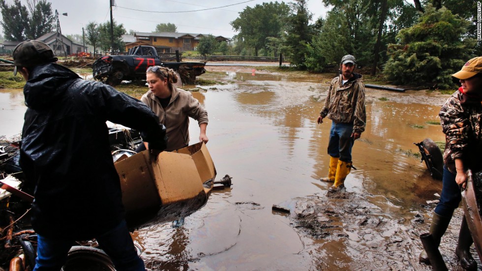 Local residents, from left, Levi Wolfe, Miranda Woodard, Tyler Sadar, and Genevieve Marquez help salvage and clean property after days of flooding in Hygeine, Colorado, on September 16.