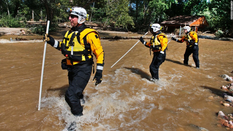 Members of the FEMA Urban Search and Rescue Nebraska Task Force 1 use probes to test for water depth while crossing floodwaters looking for missing people near Longmont, Colorado, on September 17. Stranded flood victims are being rescued by military helicopters and vehicles.