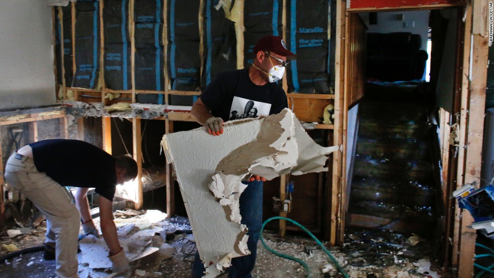 David Soleta, right, and family friend John Rice remove destroyed and contaminated walls on September 18 from Soleta&#39;s father-in-law&#39;s home, which was heavily damaged by floodwaters that swept through Longmont.