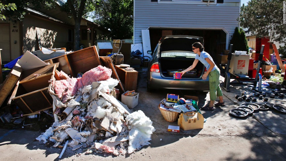 A woman disposes of ruined items from her home in Longmont on Wednesday, September 18.