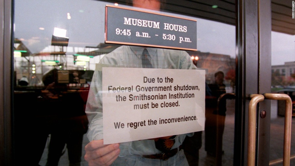 An employee hangs a sign on the door of the Smithsonian&#39;s National Air and Space Museum in Washington on November 14, 1995, marking the start of the government shutdown.