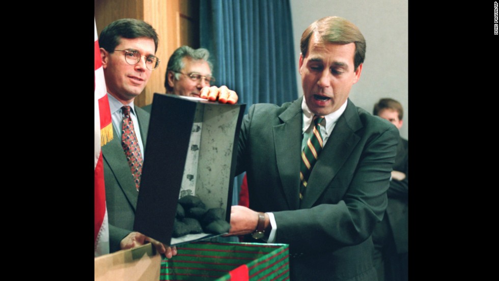 Rep. John Boehner dumps out coal, which he called a Christmas gift to President Clinton, during a news conference about the federal budget on December 21, 1995.