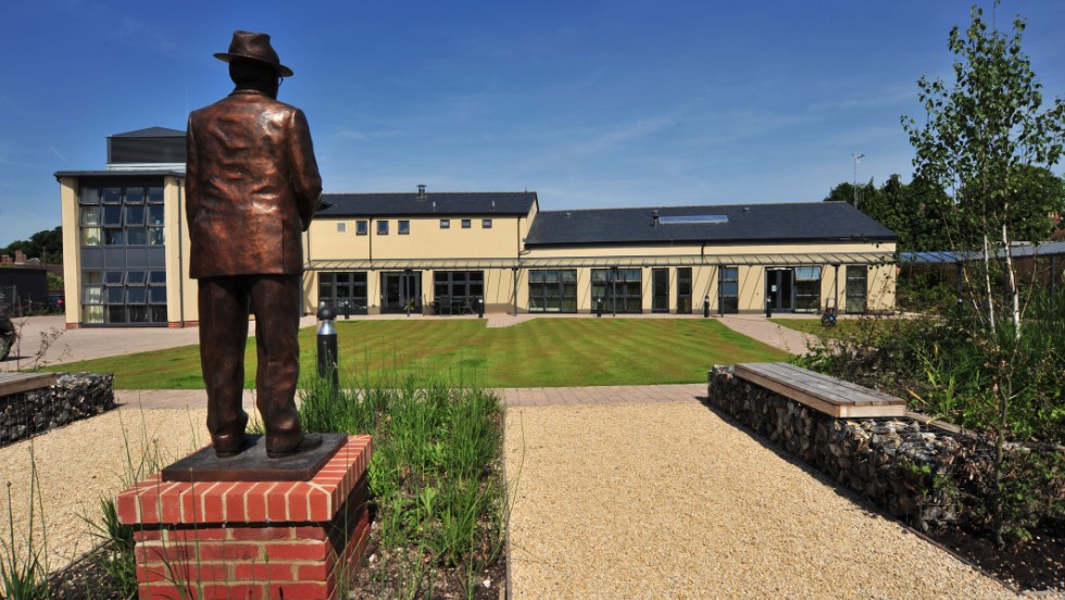 A statue of IJF founder Lord Oaksey surveys the state-of-the-art rehabilitation center that bears his name in Lambourn, England. Opened by Princess Anne in 2009, Oaksey House caters for anyone who has suffered a severe horse-related injury and has five permanent residents. 