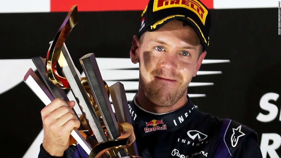 Red Bull&#39;s Sebastian Vettel lifts the trophy under lights following his victory at the Singapore Grand Prix, F1&#39;s only night race.