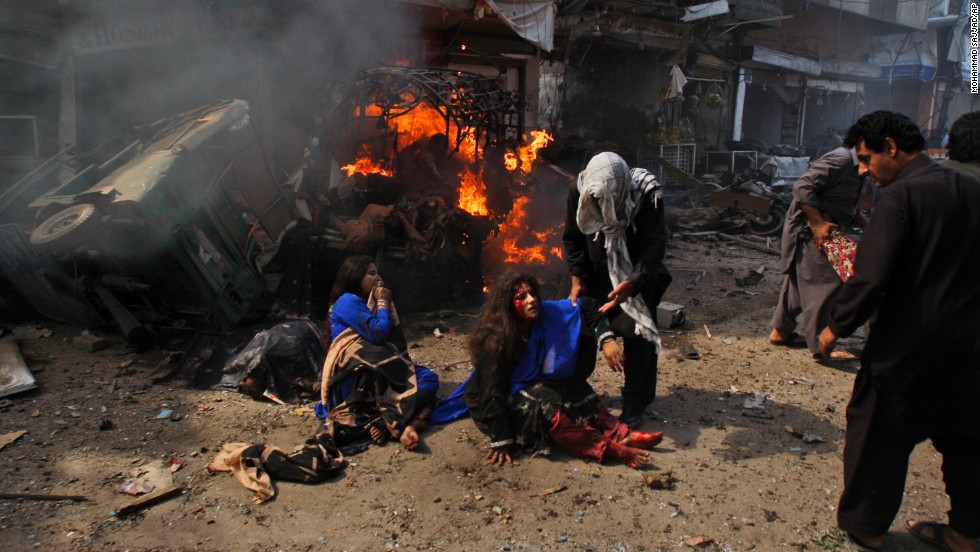 People help injured women at the site of the explosion in Peshawar on September 29.