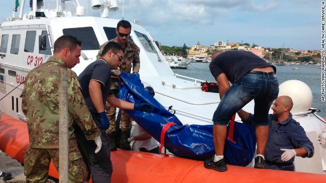 The body of a drowned migrant is unloaded from a Coastguard boat in the port of Lampedusa.