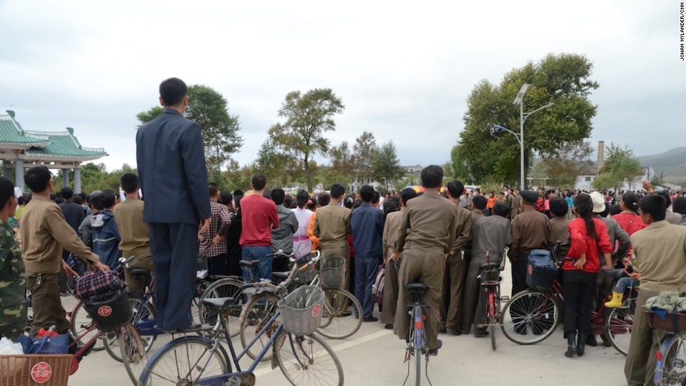 Huge crowds -- some of whom standing on their own bikes -- as they await cyclists by the race finish line in Rason.