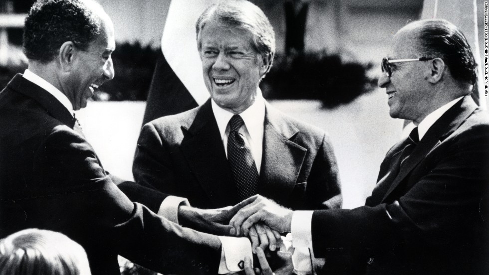 President Jimmy Carter, center, Egyptian President Anwar Sadat, left, and Israeli Prime Minister Menachem Begin join hands after signing the Camp David Accords. Sadat and Begin won the Nobel Peace Prize in 1978. 