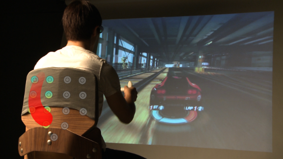Surround Haptics, by Disney Research, uses a grid of vibrating actuators to create moving tactile strokes on your skin. It feels like someone dragging a finger across your skin. It sounds creepy but there are many applications -- maybe in a motorcycle jacket that would let you feel the traffic around you or in gaming, feeling every motion. 