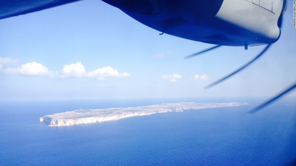 The view out of a window on the Frontex surveillance plane shows the Italian island of Lampedusa. More than 300 migrants died in a shipwreck while attempting to reach the island in early October.