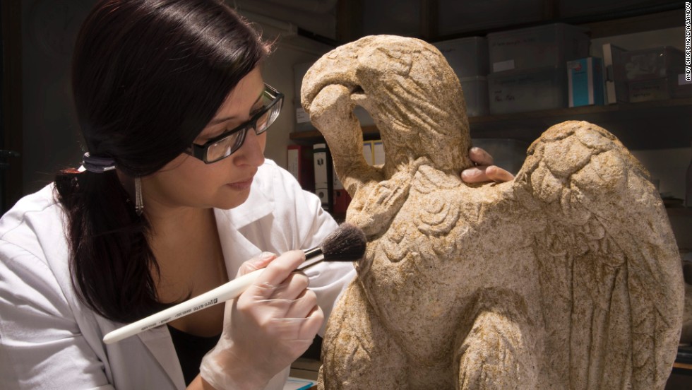 Museum of London Archaeology conservator Luisa Duarte dusts a Roman sculpture of an eagle clutching a serpent, dating from the first or second century. It was dug up at a site in the City of London, the UK capital&#39;s financial center, which is known once to have been home to a Roman cemetery. The statue is 26 inches tall and made of limestone. It will be on display at the Museum of London for the next six months.