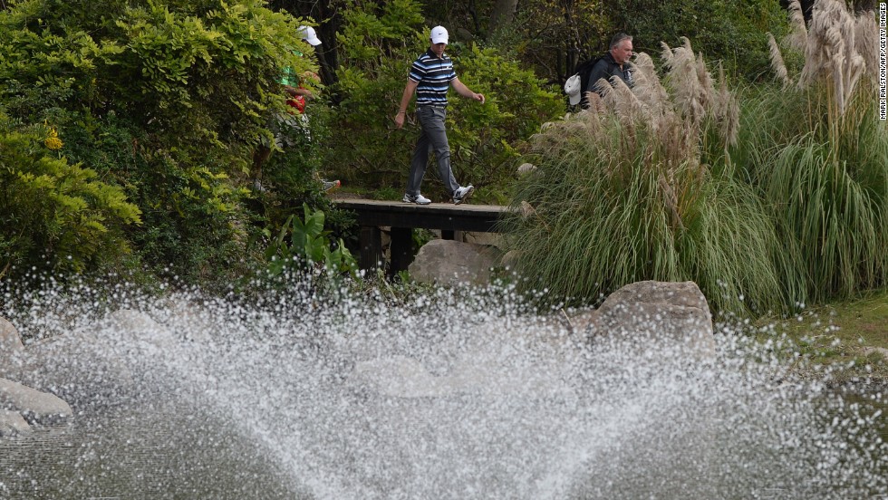 McIlroy walks over the bridge next to the spectacular fountain on the eighth hole at Sheshan International. 