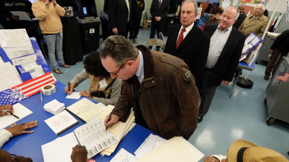 Bloomberg, second in line, waits to receive his ballot at Public School 6. 