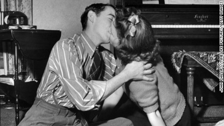 Teens kiss during a game of spin the bottle at a party in 1942.